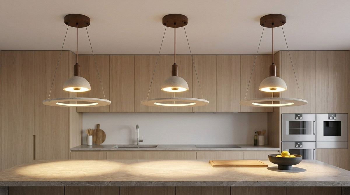 Three travertine pendant lights hanging in a row above a stone kitchen island in a modern kitchen