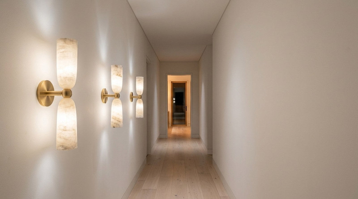 Narrow hallway lit by slim alabaster wall lamps washing light up and down the wall