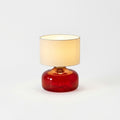 Glass and Fabric Table Lamp, switched on against a plain studio background