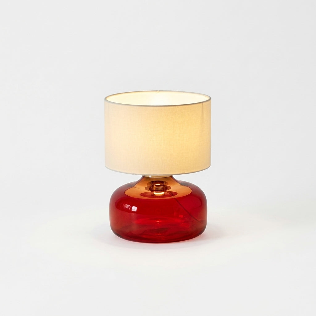 Glass and Fabric Table Lamp, switched on against a plain studio background