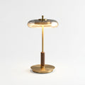 Glass, Walnut and Brass Table Lamp, switched on against a plain studio background