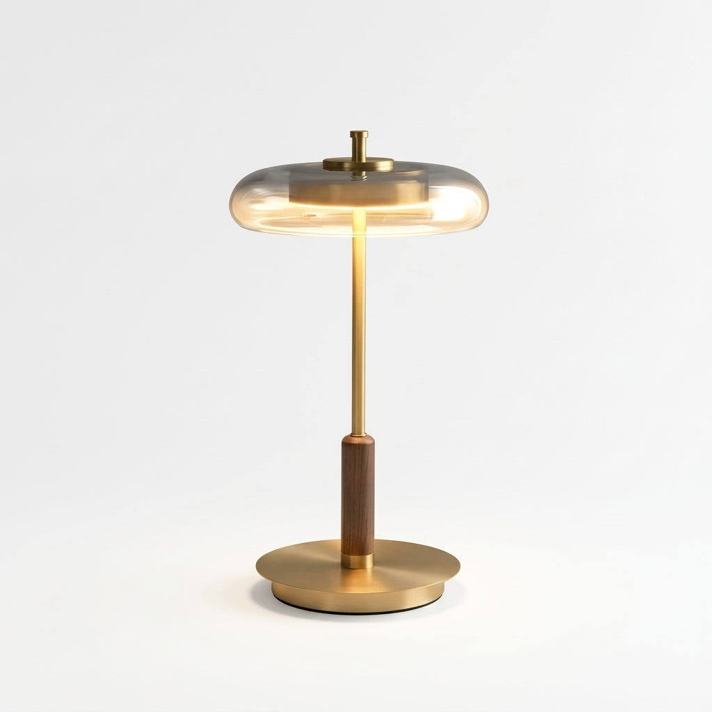 Glass, Walnut and Brass Table Lamp, switched on against a plain studio background