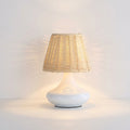 Woven Bamboo Table Lamp, switched on against a plain studio background