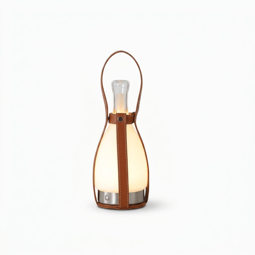 Leather and Glass Portable Lamp, switched on against a plain studio background