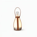Leather and Glass Portable Lamp, switched on against a plain studio background