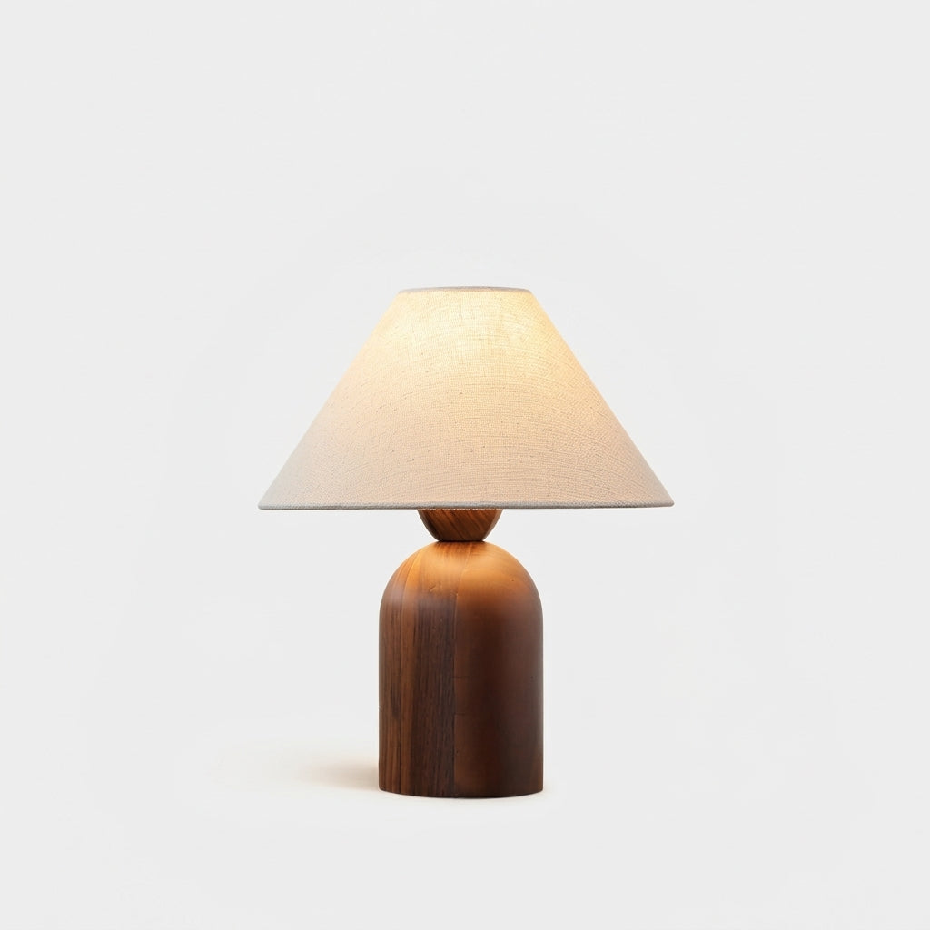 Linen and Walnut Table Lamp, switched on against a plain studio background