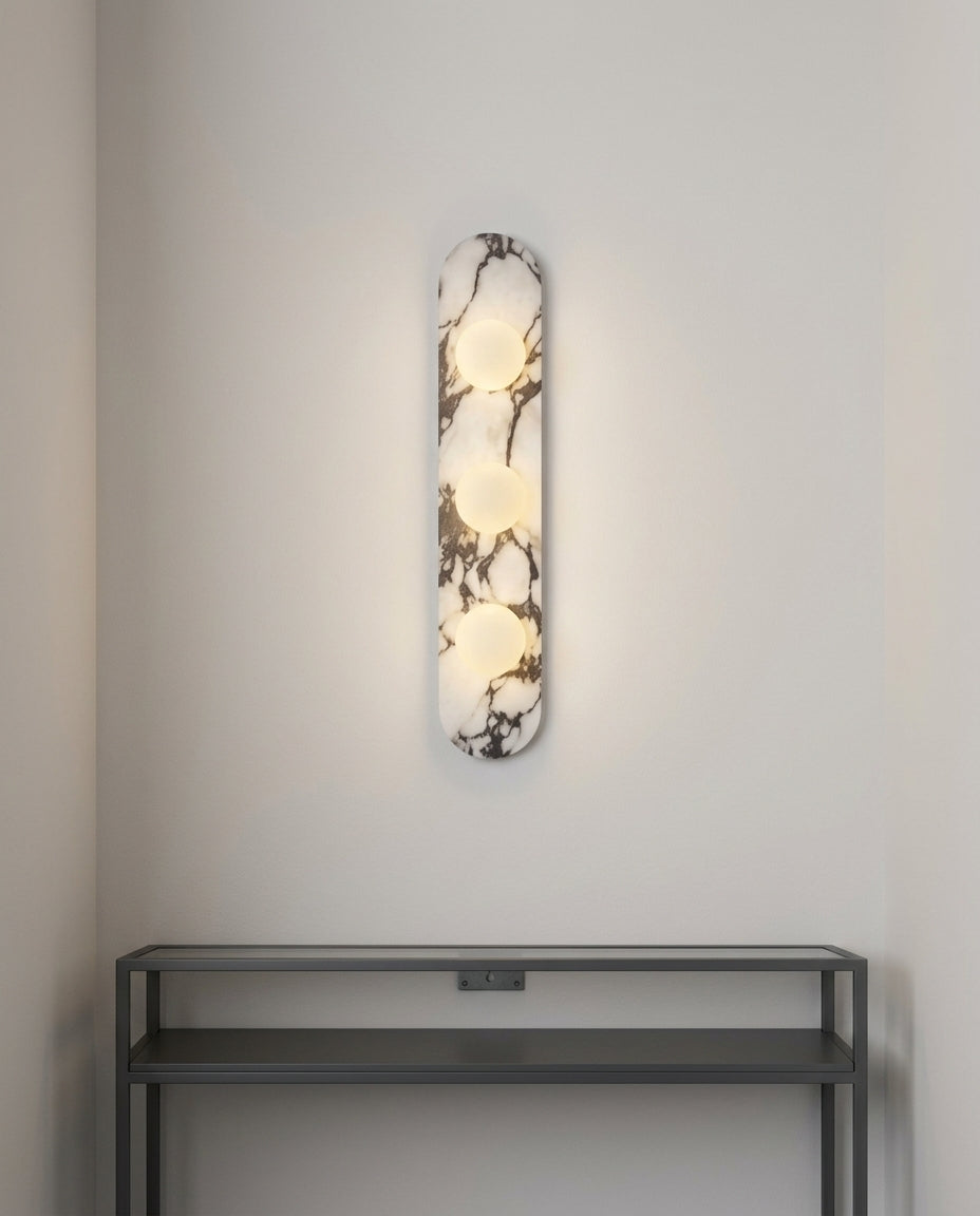 Marble and Opal Glass Wall Light mounted on an off-white hallway wall above a low console, evening, warm pool of light on the wall