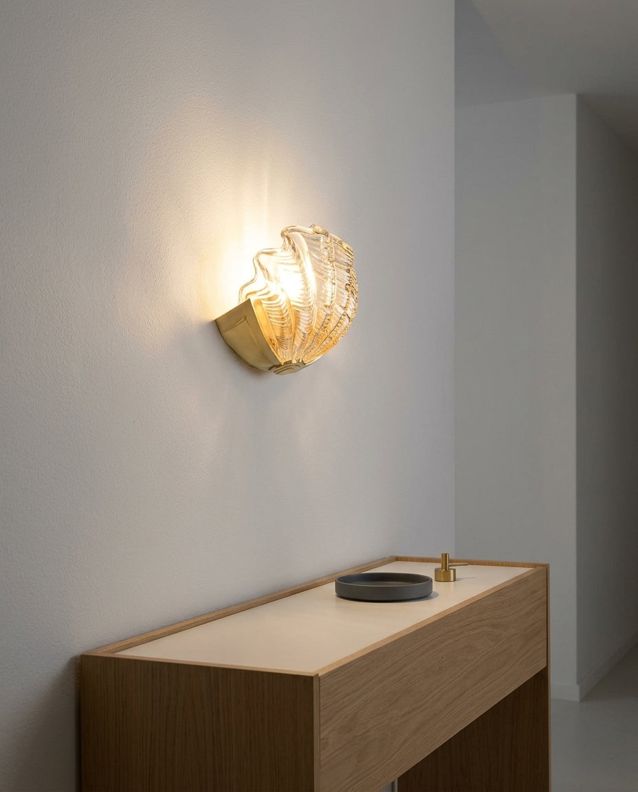 Seashell Glass and Brass Wall Sconce mounted on an off-white hallway wall above a low console, evening, warm pool of light on the wall