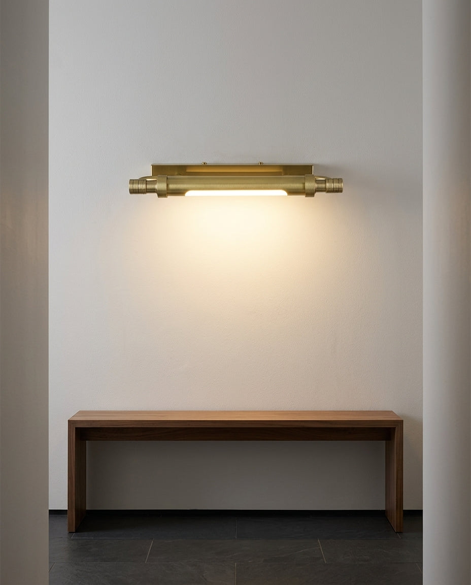 Brass Linear Wall Sconce mounted on an off-white hallway wall above a low console, evening, warm pool of light on the wall