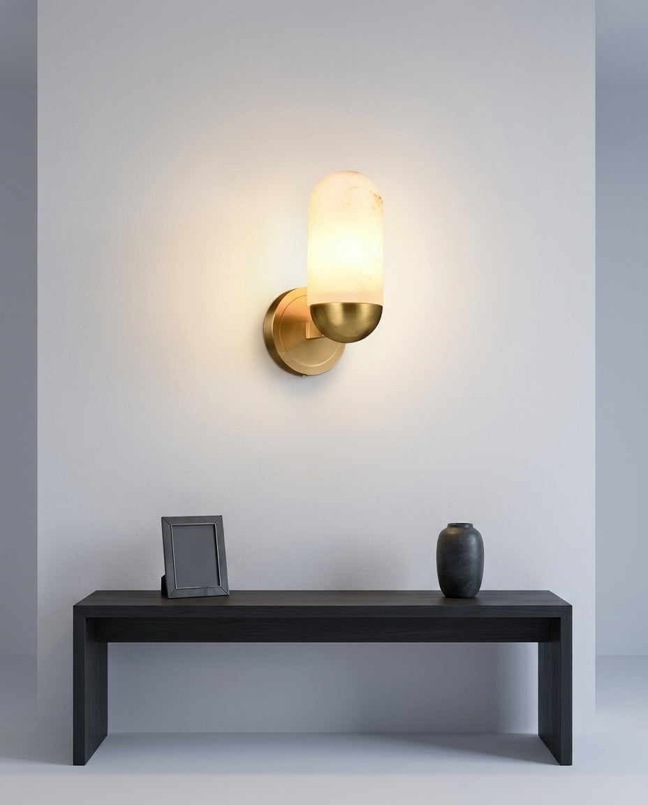 Alabaster Capsule Wall Light mounted on an off-white hallway wall above a low console, evening, warm pool of light on the wall