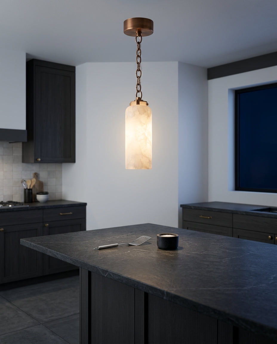 Slim Alabaster and Brass Pendant Light hanging above a kitchen island with a stone worktop, modern American kitchen, evening