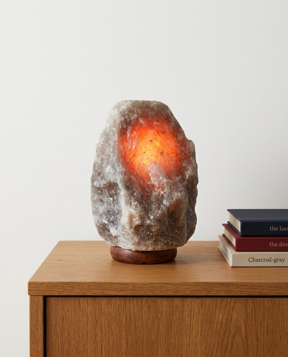 Salt Stone Table Lamp on an oak sideboard against an off-white wall, evening, a small stack of books beside it