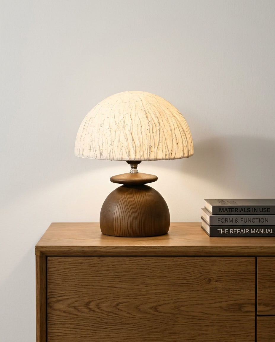 Paper Shade and Wood Table Lamp on an oak sideboard against an off-white wall, evening, a small stack of books beside it