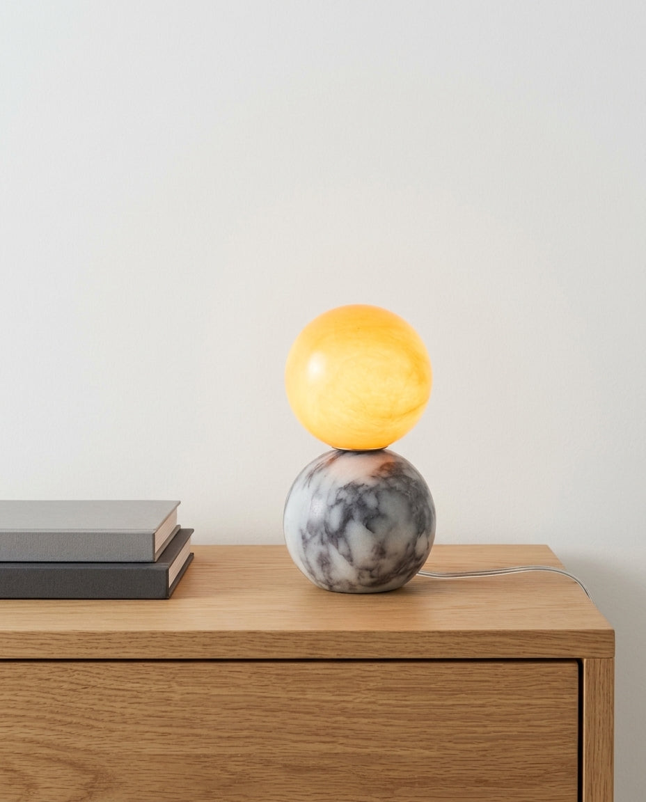 Marble and Alabaster Table Lamp on an oak sideboard against an off-white wall, evening, a small stack of books beside it