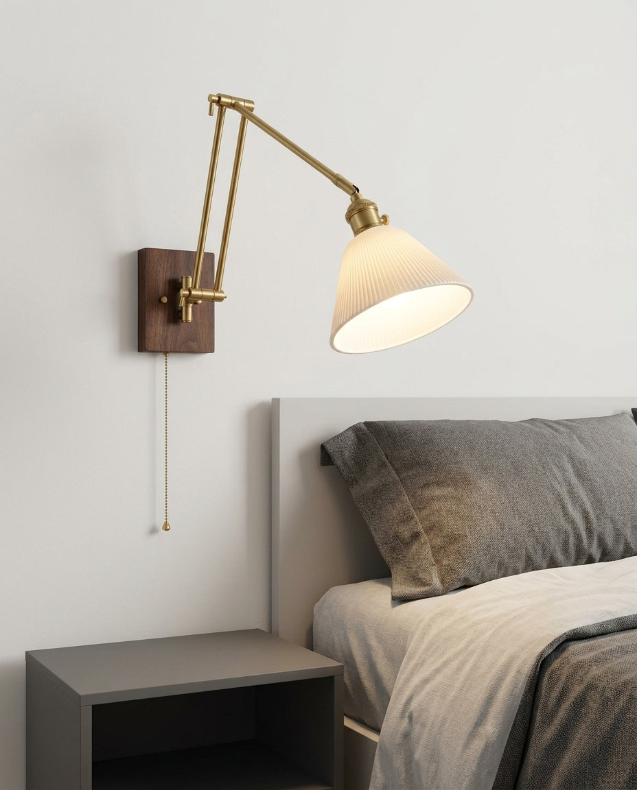Ceramic Swing Arm Wall Sconce mounted on the wall beside a bed in place of a bedside lamp, reading light angled down