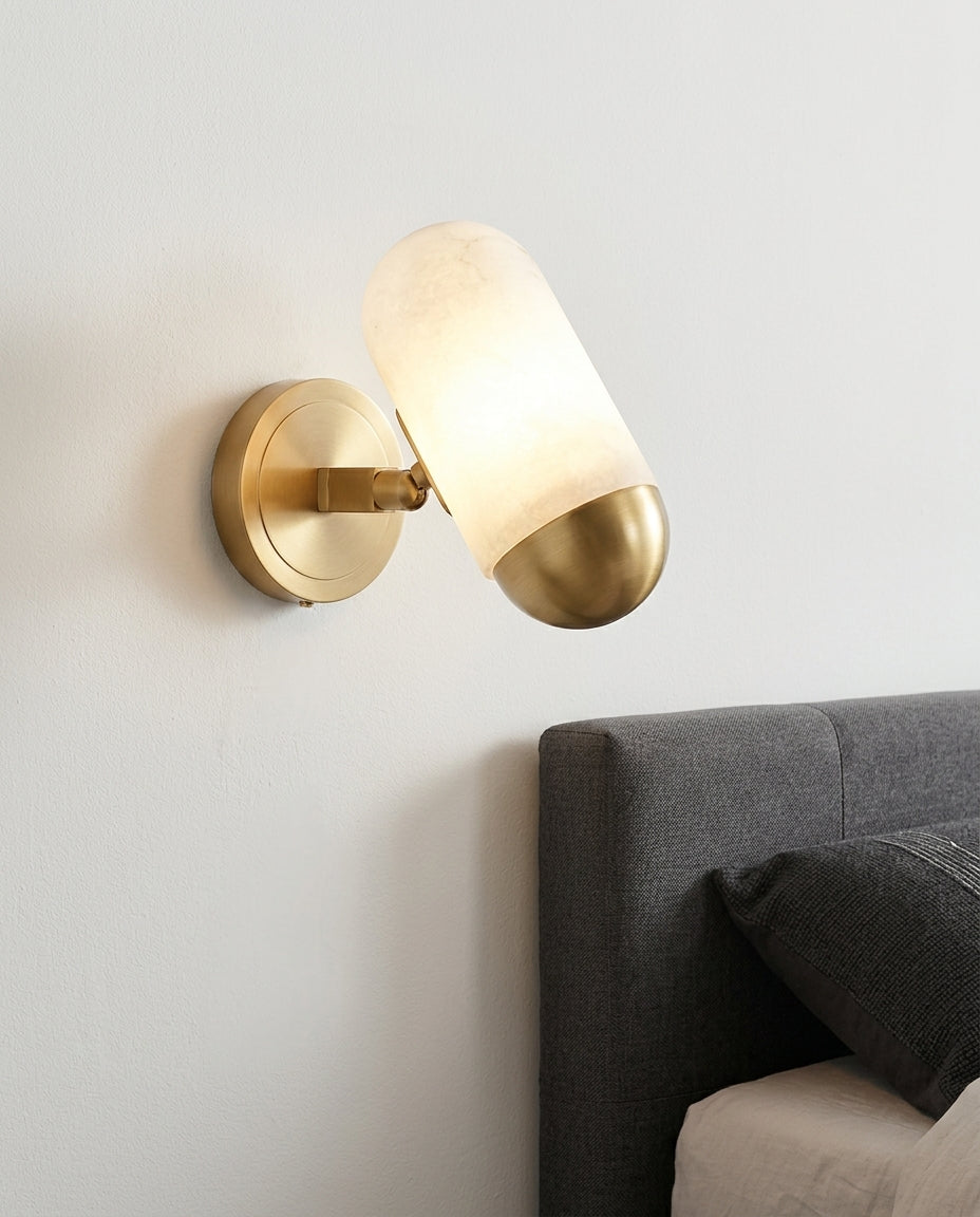 Alabaster Capsule Wall Light mounted on the wall beside a bed in place of a bedside lamp, reading light angled down