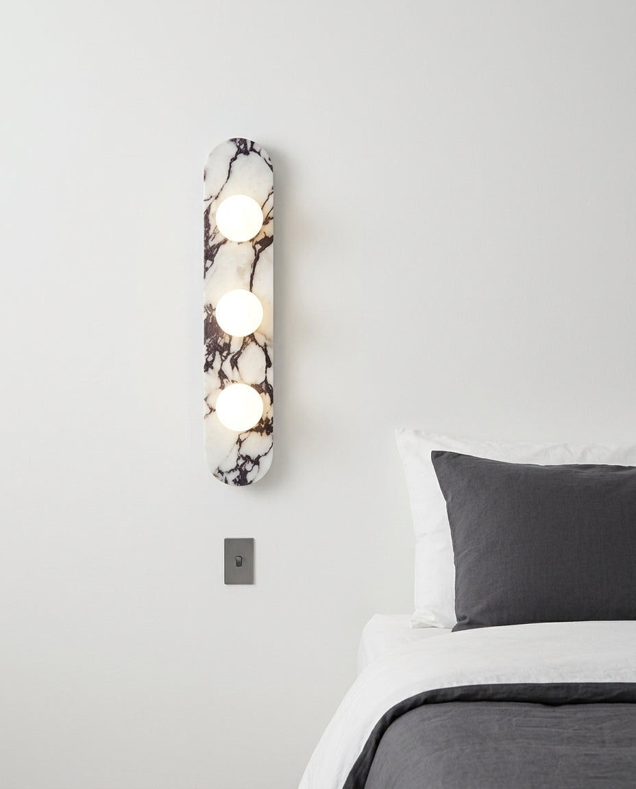 Marble and Opal Glass Wall Light mounted on the wall beside a bed in place of a bedside lamp, reading light angled down