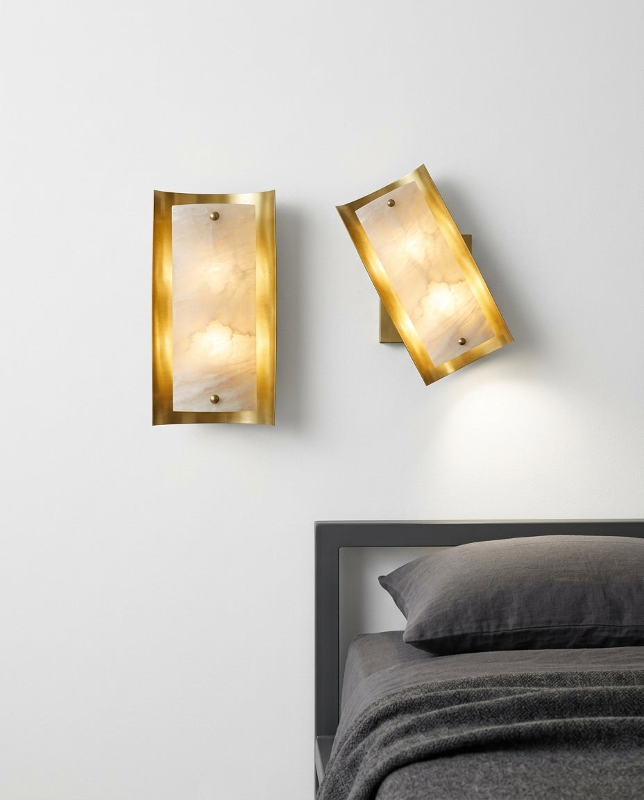 Tall Alabaster and Brass Wall Lamp mounted on the wall beside a bed in place of a bedside lamp, reading light angled down