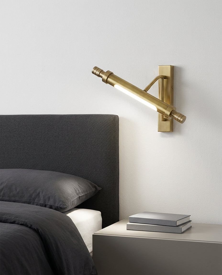 Brass Linear Wall Sconce mounted on the wall beside a bed in place of a bedside lamp, reading light angled down