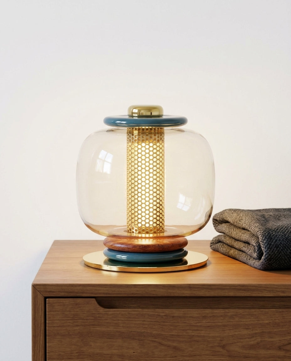 Polished Metal and Glass Table Lamp on a bedside table beside a folded throw, warm evening light
