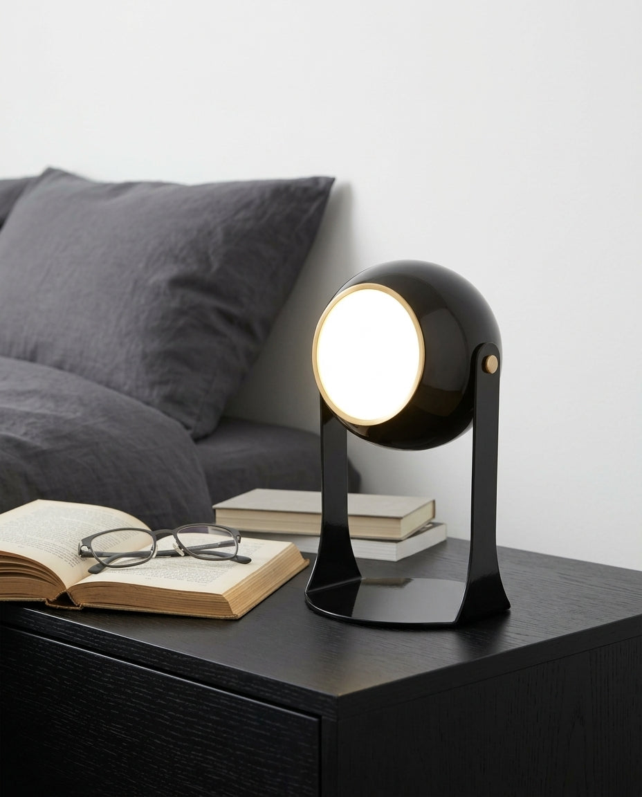 Folding Acrylic Cordless Lamp on a bedside table beside a folded throw, warm evening light