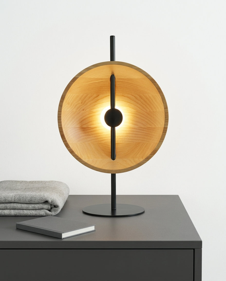 Wood Disc Table Lamp on a bedside table beside a folded throw, warm evening light