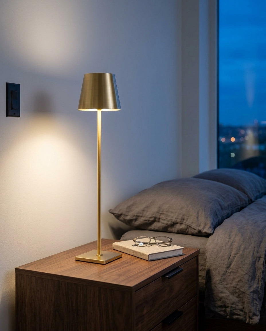 Cordless Aluminum Table Lamp, Set of Two on a bedside table beside a folded throw, warm evening light