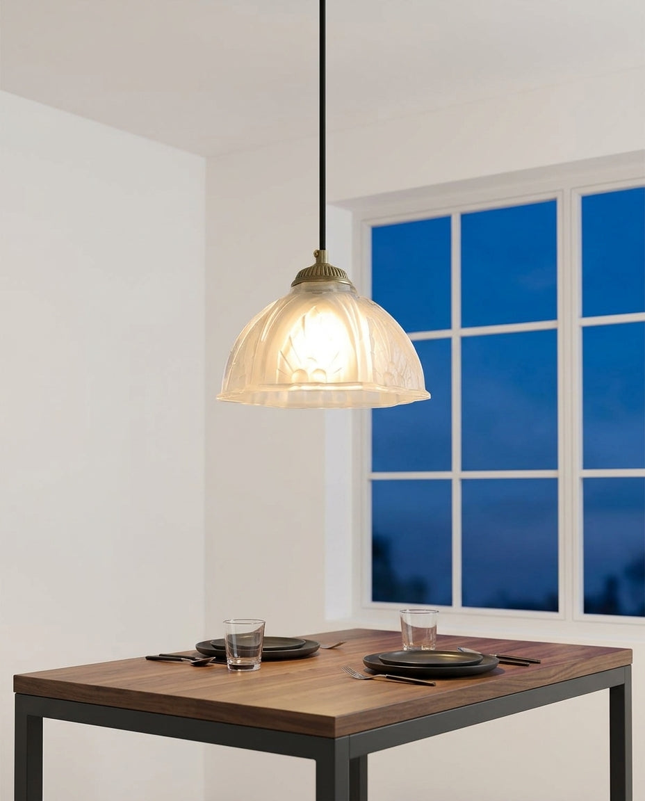 Scalloped Glass Petal Pendant Light hanging above a walnut dining table set for two, blue-hour light through a large window