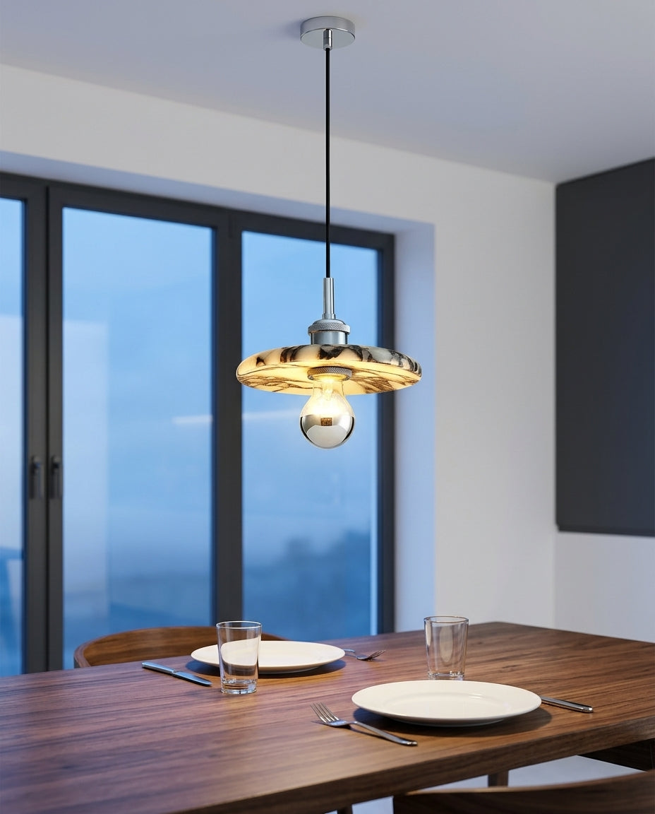 Marble Cylinder Pendant Light hanging above a walnut dining table set for two, blue-hour light through a large window
