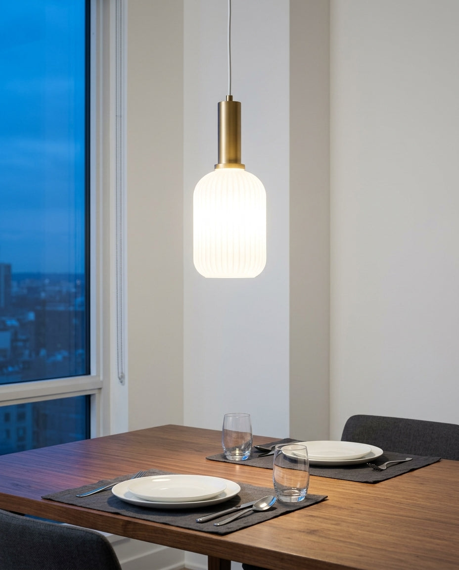 Bubble Glass Pendant Light hanging above a walnut dining table set for two, blue-hour light through a large window