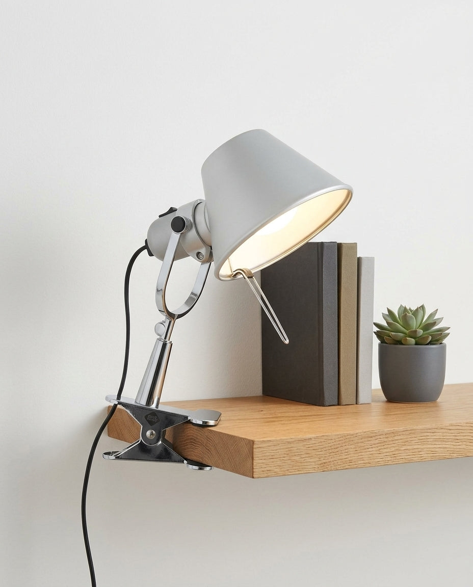 Clip-On Task Lamp on an oak shelf beside a few hardback books and a small plant, evening