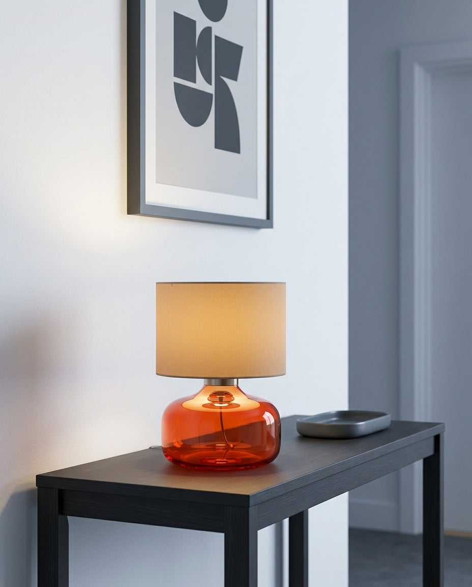 Glass and Fabric Table Lamp on an entryway console table below a framed print, evening