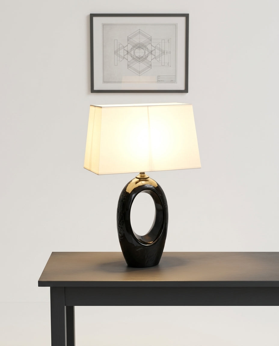 Ceramic and Fabric Table Lamp on an entryway console table below a framed print, evening