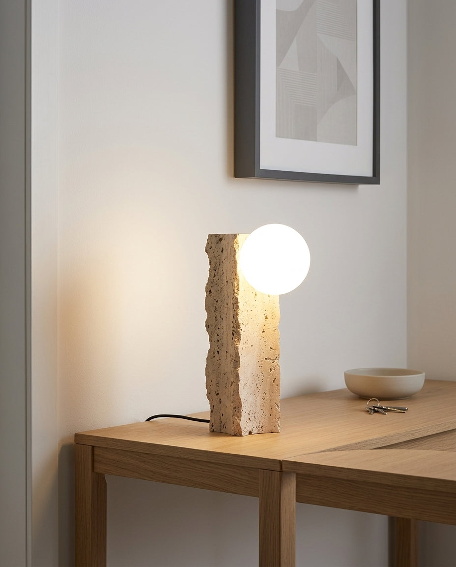 Travertine Column Table Lamp on an entryway console table below a framed print, evening