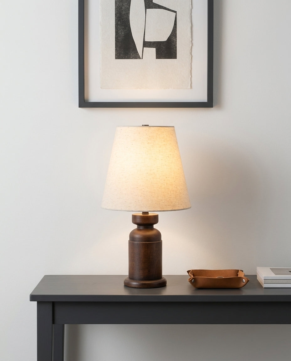 Walnut Wood Table Lamp on an entryway console table below a framed print, evening