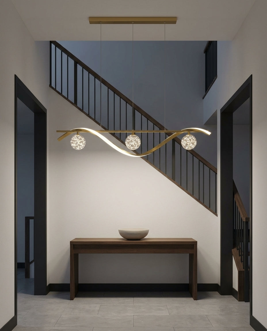 Globe and Metal Pendant hanging in a double-height entryway above a console table, evening