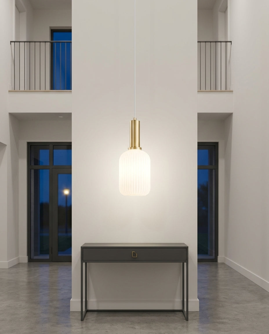 Bubble Glass Pendant Light hanging in a double-height entryway above a console table, evening