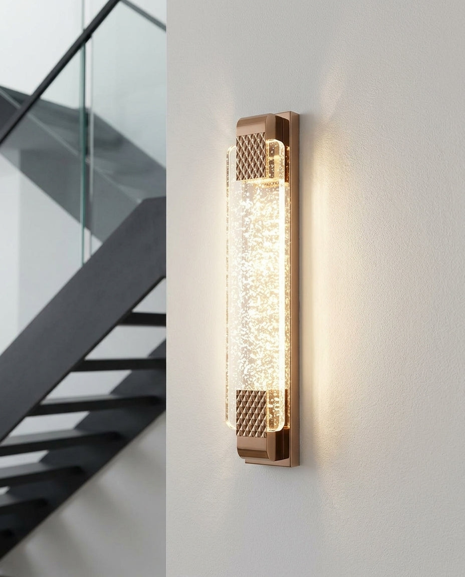 Crystal and Gold Rectangular Wall Light mounted on the wall of a modern staircase, the light grazing the wall texture