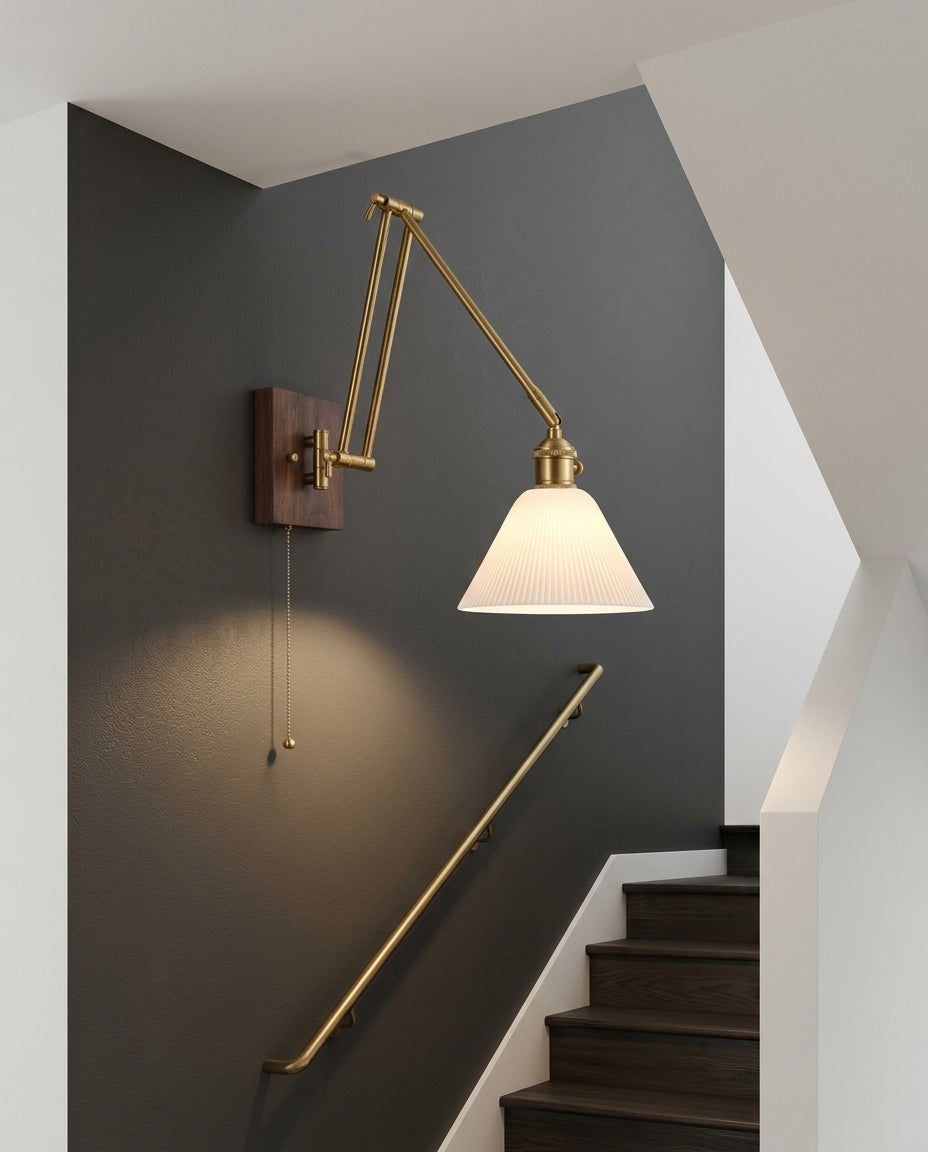 Ceramic Swing Arm Wall Sconce mounted on the wall of a modern staircase, the light grazing the wall texture