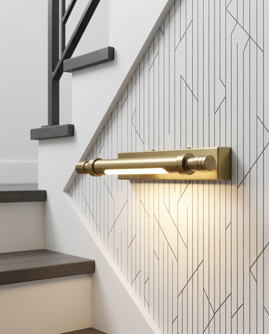 Brass Linear Wall Sconce mounted on the wall of a modern staircase, the light grazing the wall texture