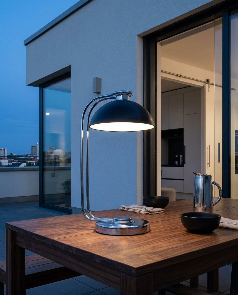 Chrome Dome Cordless Table Lamp on an outdoor dining table on a modern terrace at dusk, no cable anywhere in frame