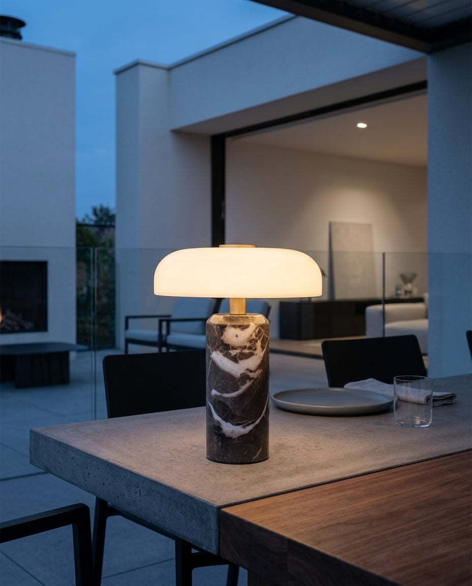 Marble and Glass Portable Lamp on an outdoor dining table on a modern terrace at dusk, no cable anywhere in frame