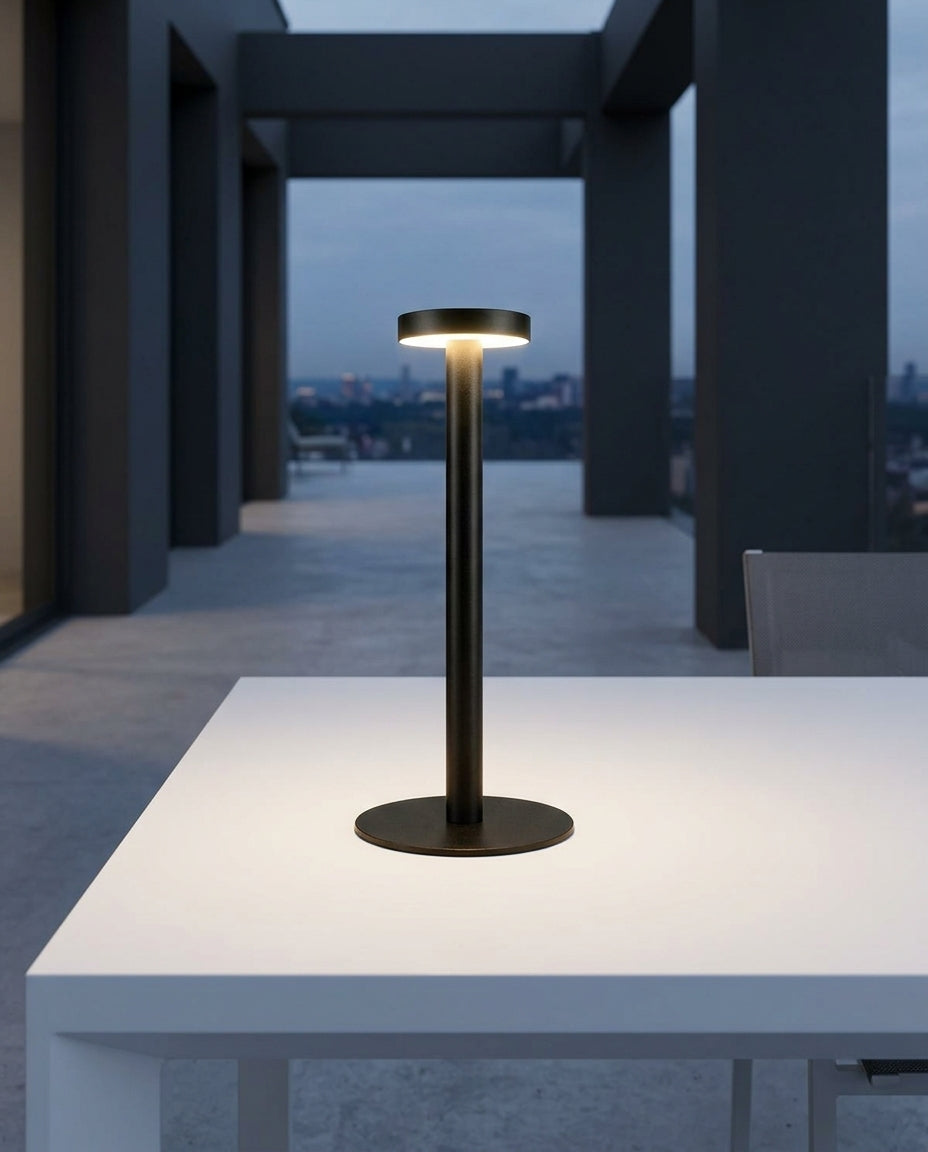 Sand-Finish Aluminum Cordless Lamp on an outdoor dining table on a modern terrace at dusk, no cable anywhere in frame